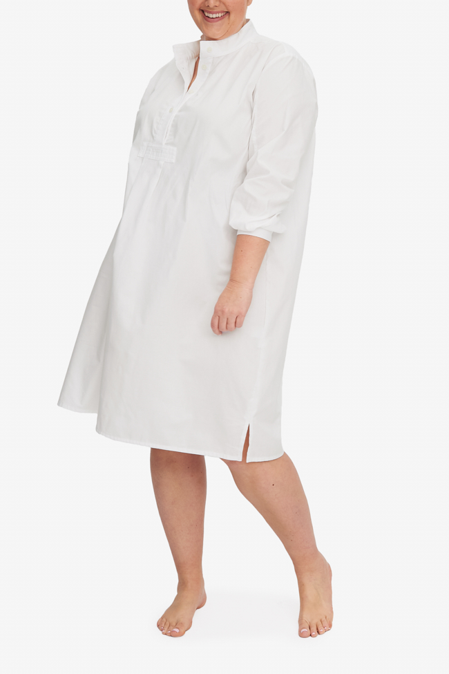 A smiling woman wears a Long Sleep Shirt in white royal oxford cotton. Simple and easy to wear, this falls below the knee on most and offers modesty as well as  comfort.